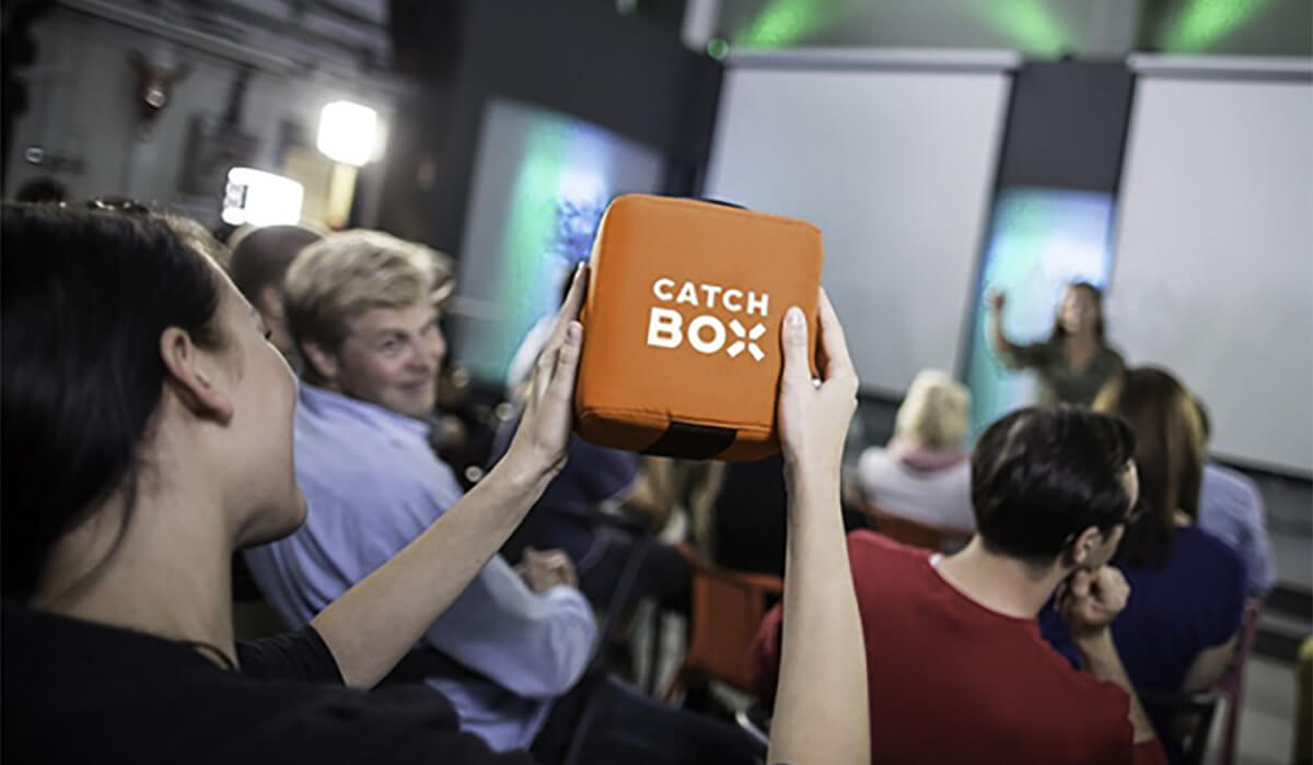 Microphone cube orange Catchbox lancé dans le public.