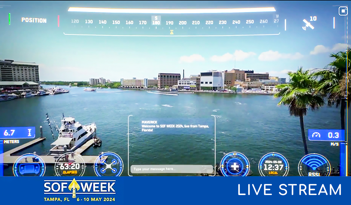 View of a waterfront cityscape in Tampa, Florida, with boats on the water, palm trees, and digital overlay graphics indicating a live stream for “SOF Week” event, held May 6–10, 2024.